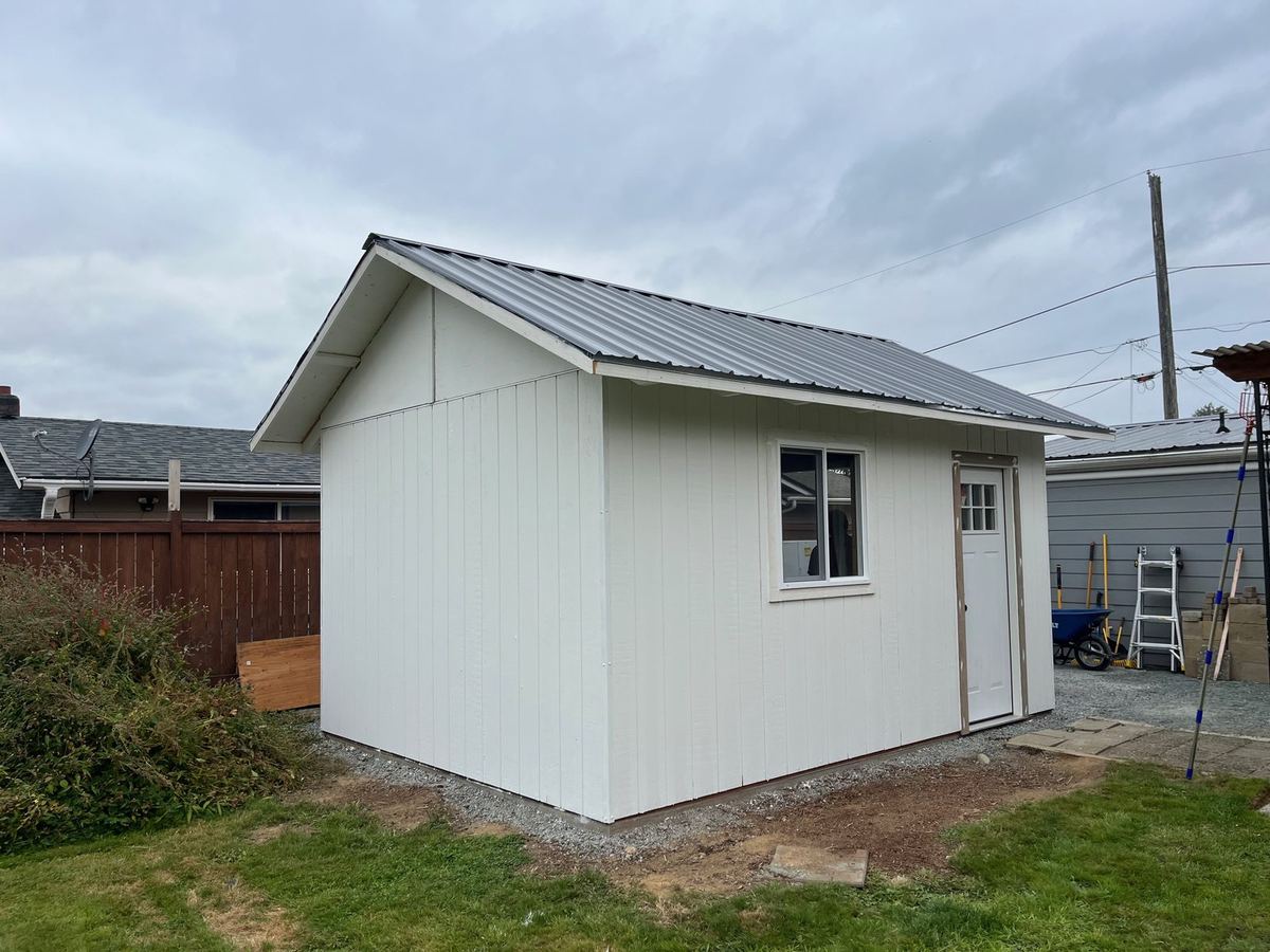 Finished outbuilding with metal roof, window, and door